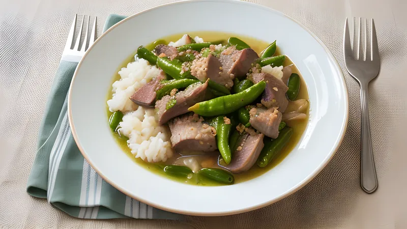 A pot of Bicol express, pork belly in orange-red coconut sauce studded with green chillies