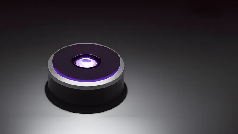 A small invented hub puck with a glowing infrared eye, mounted against a plain wall surface